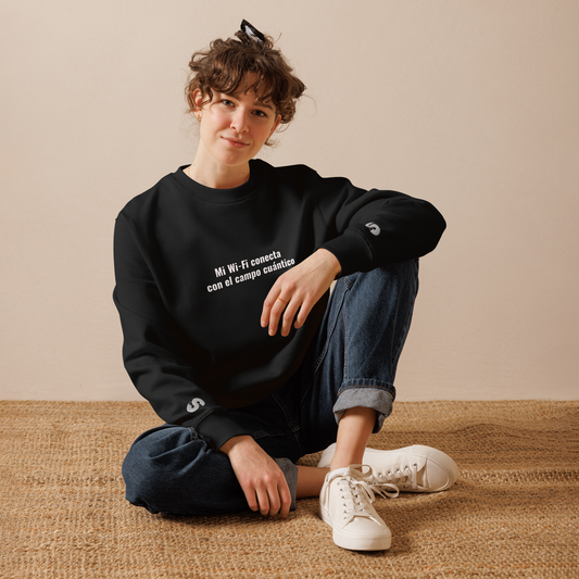 Mujer sentada con Sudadera Eco VOOM — Quantum Field Connection negra y texto blanco “Mi Wi-Fi conecta con el campo cuántico”