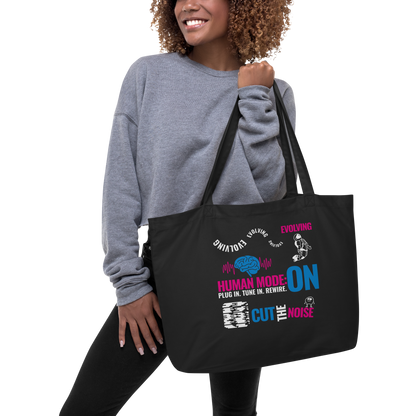 Modelo con sudadera gris sosteniendo la Ecobolsa VOOM “Human Mode: ON” con tipografía futurista y estilo urban