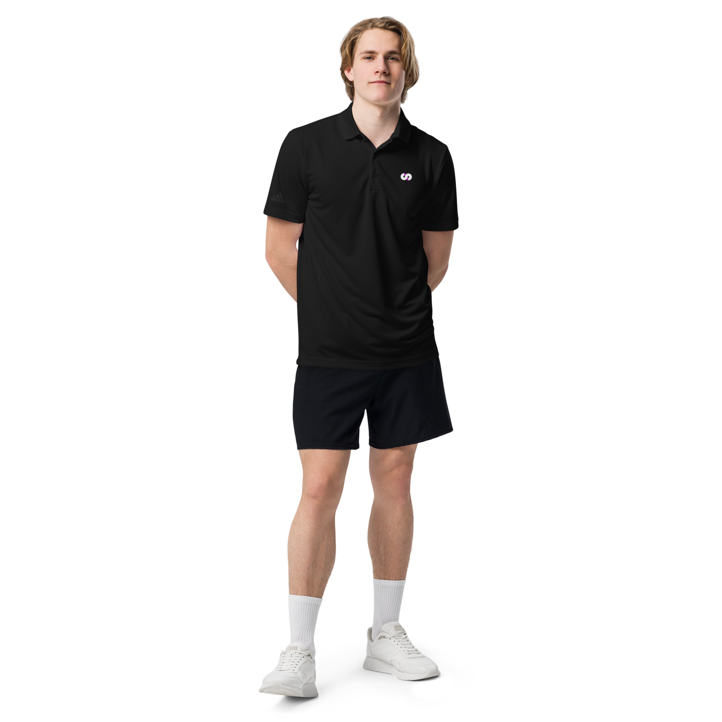 Hombre de pie con Polo Negro VOOM x adidas — The Discipline Code, corte deportivo y detalle del logo bordado en el pecho
