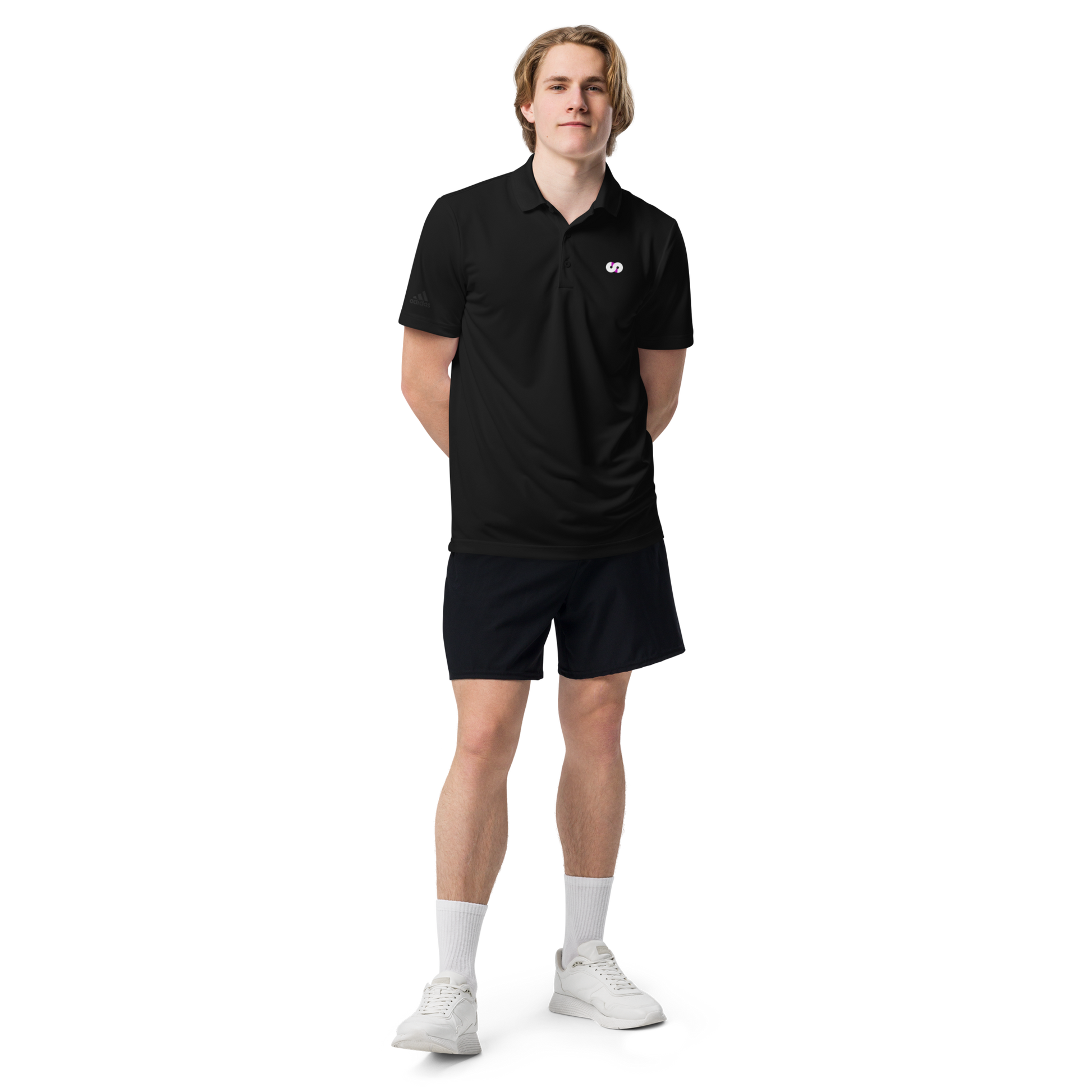 Hombre de pie con Polo Negro VOOM x adidas — The Discipline Code, corte deportivo y detalle del logo bordado en el pecho