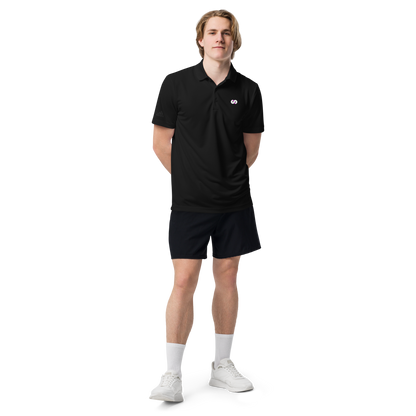 Hombre de pie con Polo Negro VOOM x adidas — The Discipline Code, corte deportivo y detalle del logo bordado en el pecho