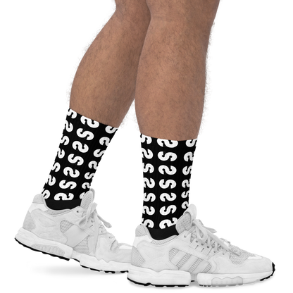 Pies masculinos con zapatos deportivos blancos usando Calcetines VOOM — The Ground Signal con patrón blanco sobre negro