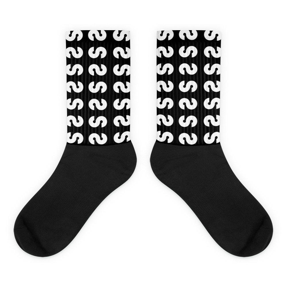 Calcetines VOOM — The Ground Signal largos con diseño repetido de "S" blanca sobre fondo negro y caña acanalada.