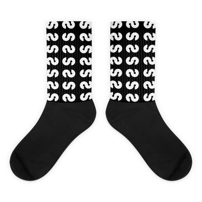 Calcetines VOOM — The Ground Signal largos con diseño repetido de "S" blanca sobre fondo negro y caña acanalada.