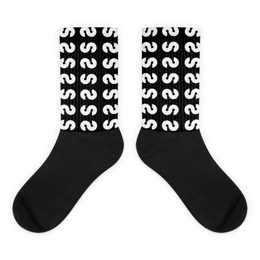 Calcetines VOOM — The Ground Signal largos con diseño repetido de "S" blanca sobre fondo negro y caña acanalada.