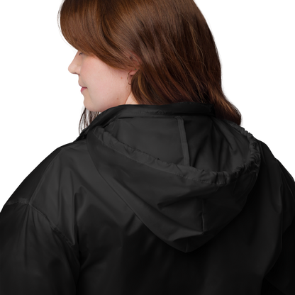 Mujer de perfil con capucha puesta del Cortavientos Negro Unisex VOOM — The Motion Code mostrando detalles en poliamida impermeable.