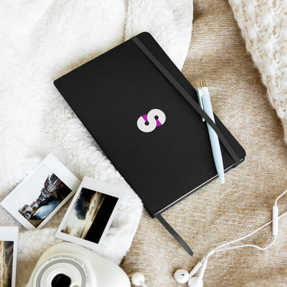 Cuaderno de Tapa Dura VOOM — The Archive Code sobre manta beige junto a fotos instantáneas y bolígrafo celeste
