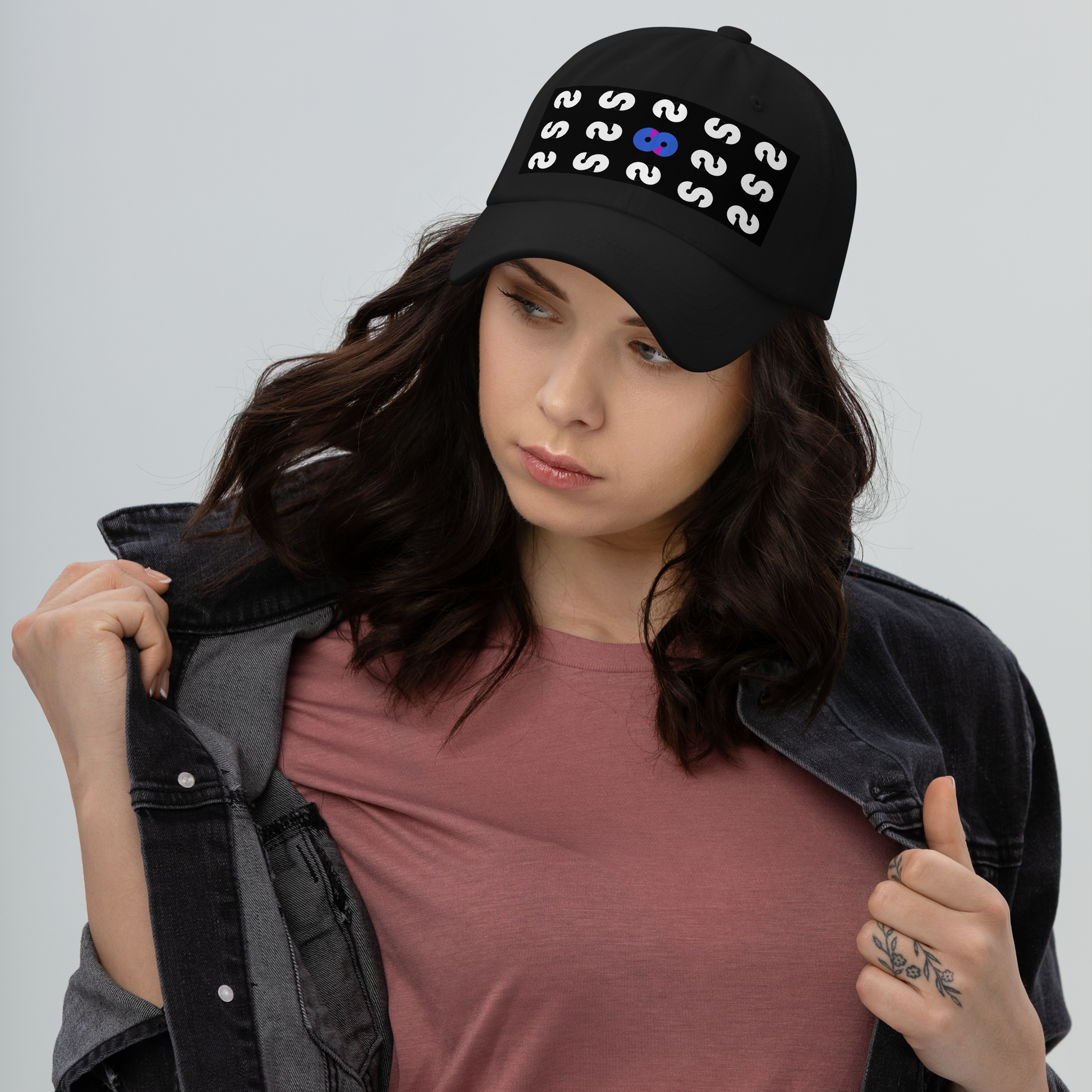 Mujer con Gorra Negra VOOM — The Pattern Code mostrando detalle del patrón repetitivo y símbolo VOOM central azul.